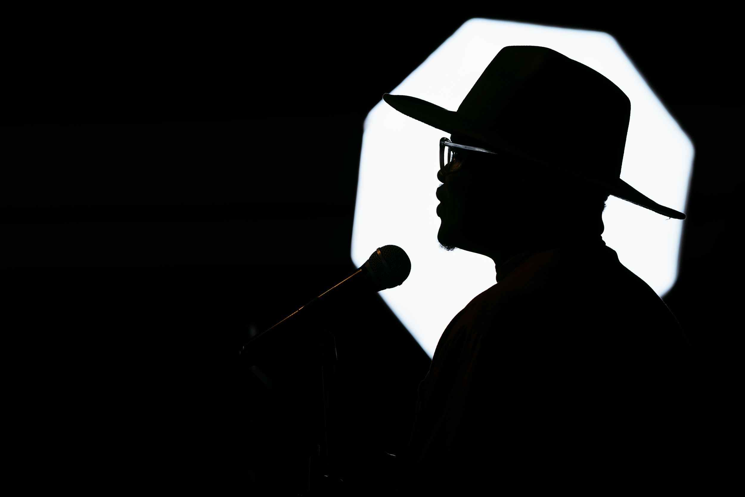 A photographer observes a group gathered in an interior space.